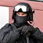 Вооружённый мужчина в чёрном шлеме и со скрытым лицом