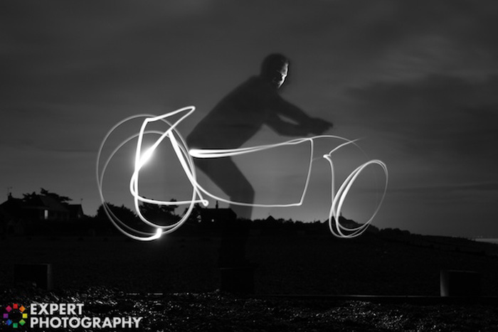 Cool night portrait of a man riding a light graffiti bike
