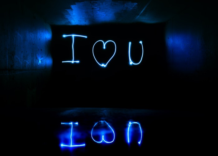 A man in front of a graffiti wall doing light painting 