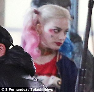 Tough cookie: The Australian actress, 25, wore blue and pink bunches and vivid makeup and appeare din character as she pouted her scarlet red lips as she waited for the crew to set up the shot