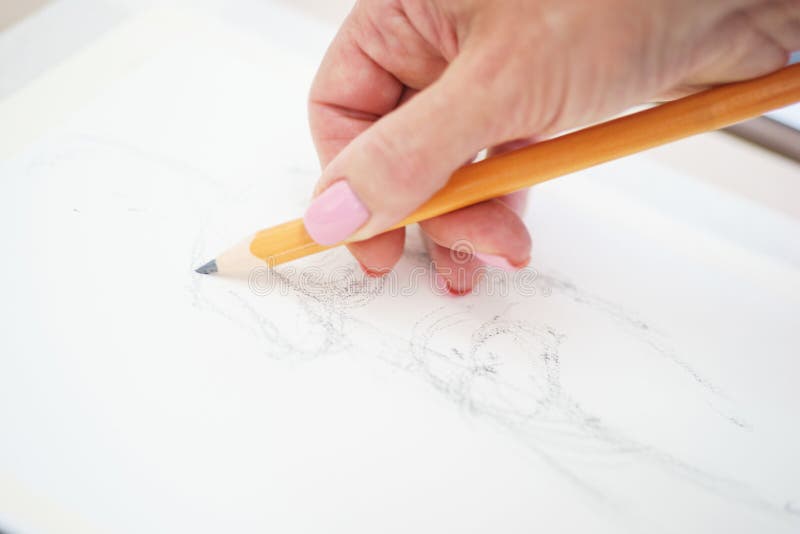 Artist with a pencil close-up while drawing a sketch on clean paper. royalty free stock images