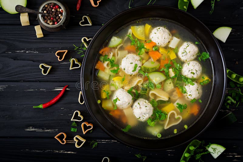 Chicken and vegetable soup with meatballs, zucchini and pasta. royalty free stock photo