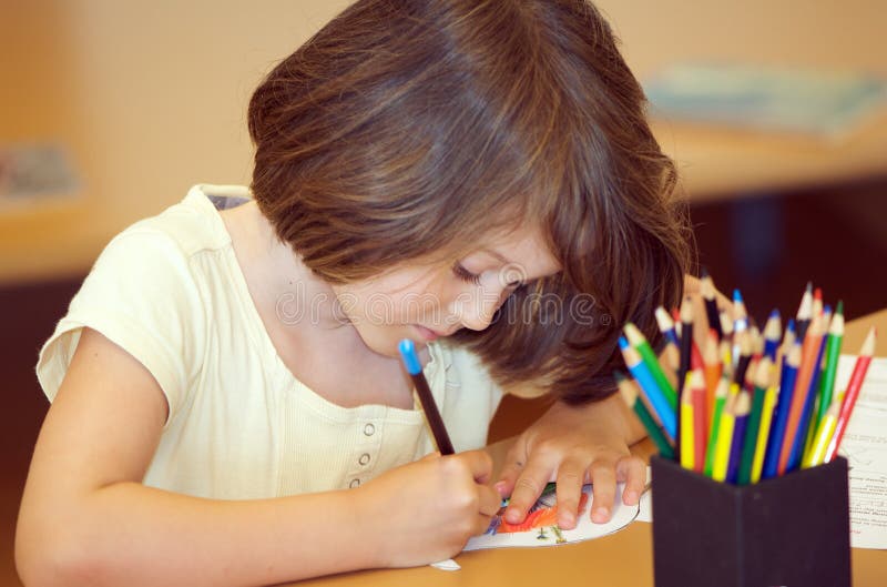 Child drawing. Child colouring in a drawing with colourful pencils stock photos