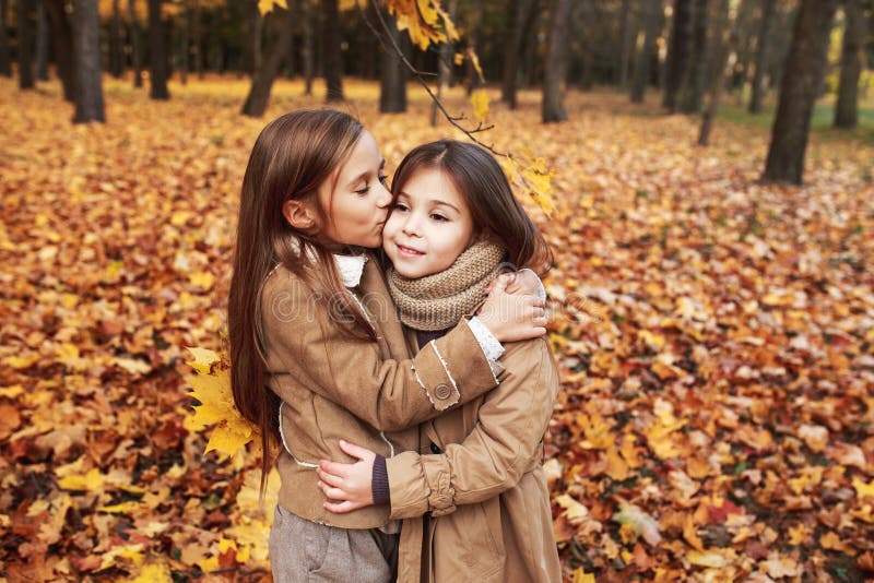 Cute two little sisters hugging in autumn park outdoor royalty free stock images