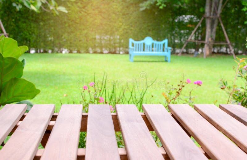 Empty perspective brown wood over blurred trees and chair in garden with sunset light background. For product display montage royalty free stock photo Empty perspective brown wood over blurred trees and chair in garden with sunset light background. For product display montage royalty free stock photo