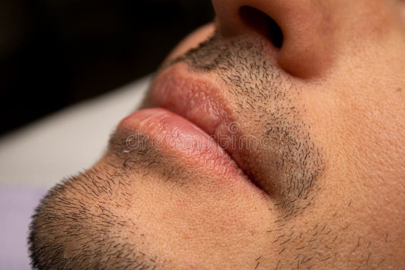 Male NU Lips. Young man closeup lips, male permanent make up, men`s bristle. Esthetician therapy and permanent makeup for men.Male NU Lips.Young man closeup stock image
