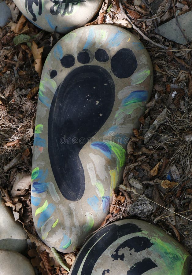 Hand-painted colorful stones. Stone painting. Human foot drawing. A stone with a drawing Human foot royalty free stock image