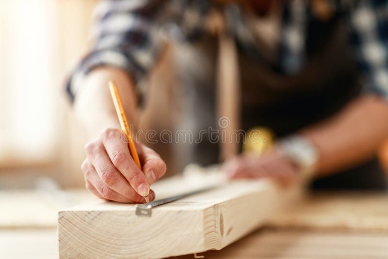 Hands of master carpenter measure distance with pencil and tape measure royalty free stock image