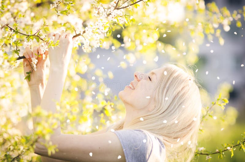 Happy woman enjoying spring, nature, falling petal royalty free stock photo