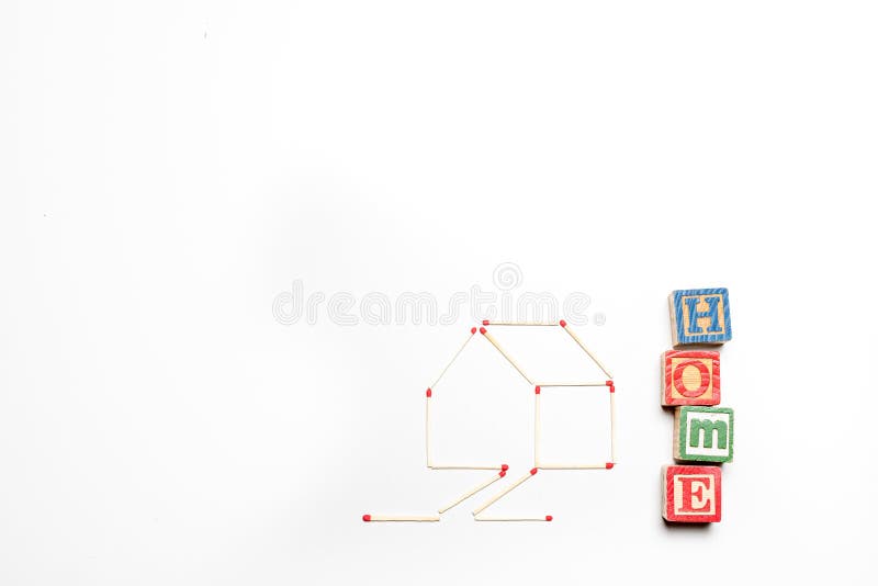 House made of matchsticks with the word `home` written in blocks alongside. House made of matchsticks on an isolated white background with the word `home` stock photos