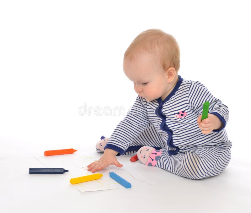 Infant child baby toddler sitting drawing painting with color pe. Ncils crayons on a white background stock photo