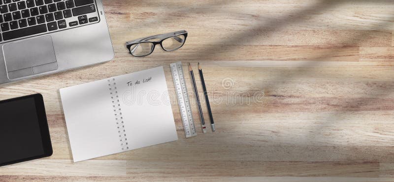 Laptop and office supplies on workplace desk with sun cast from windows with copy space. Laptop, Tablet, Notepad and eyeglasses on the business office workplace stock photography