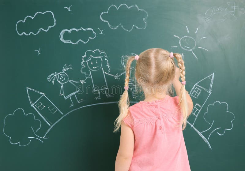 Little child drawing family with white chalk. On blackboard royalty free stock photo