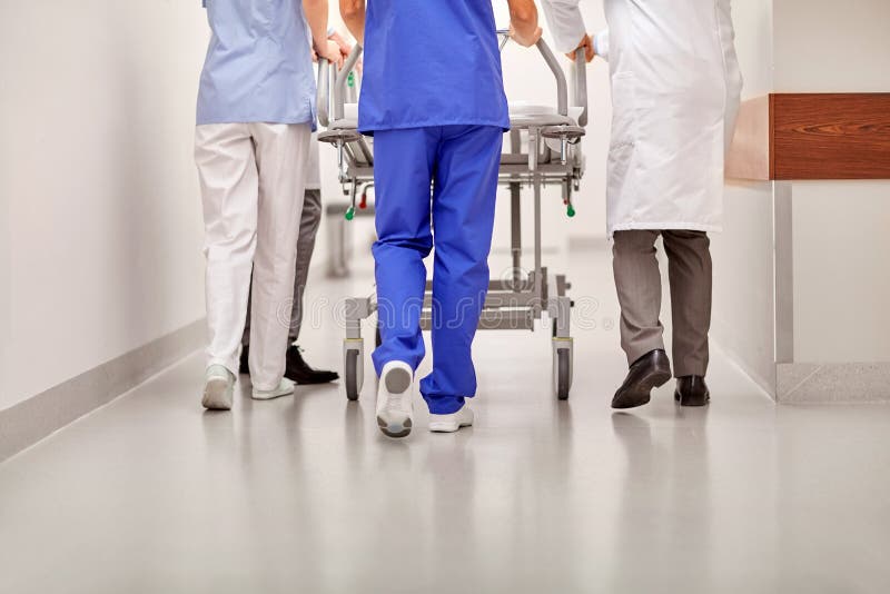 Medics carrying hospital gurney to emergency room. Profession, people, healthcare, reanimation and medicine concept - group of medics or doctors carrying royalty free stock image Medics carrying hospital gurney to emergency room. Profession, people, healthcare, reanimation and medicine concept - group of medics or doctors carrying royalty free stock image