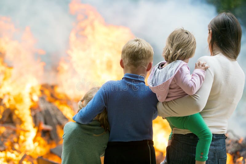 Mother with children at burning house background. Family of mother with children at burning house background stock photos Mother with children at burning house background. Family of mother with children at burning house background stock photos