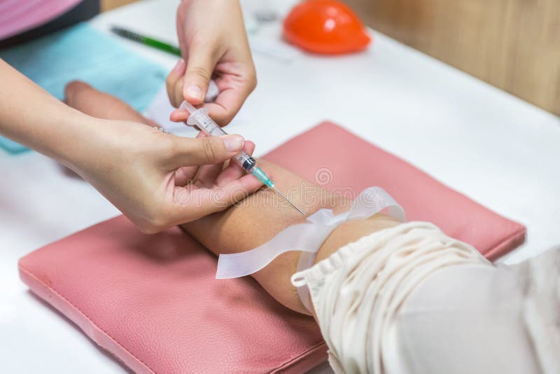 Nurse pricking needle syringe in the arm patient drawing blood sample. For blood test stock images