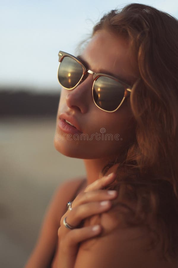Portrait of a young beautiful woman with long curly hair in sunglasses stock photos
