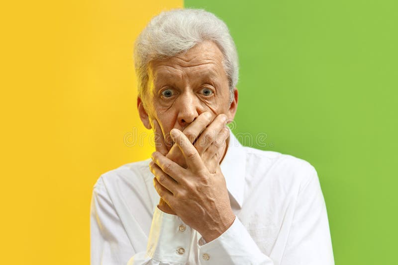 Serious frightened male keeps fore finger on lips. Serious senior frightened male keeps fingers on lips, tries to keep conspiracy, says: Shh, make silence please stock images