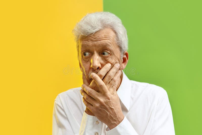 Serious frightened male keeps fore finger on lips. Serious senior frightened male keeps fingers on lips, tries to keep conspiracy, says: Shh, make silence please royalty free stock images