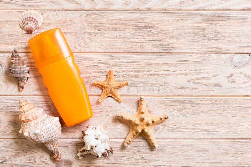 Sun protection cream bottle and seashells on wooden background with copy space. flat lay concept of summer travel vacation.  royalty free stock photos