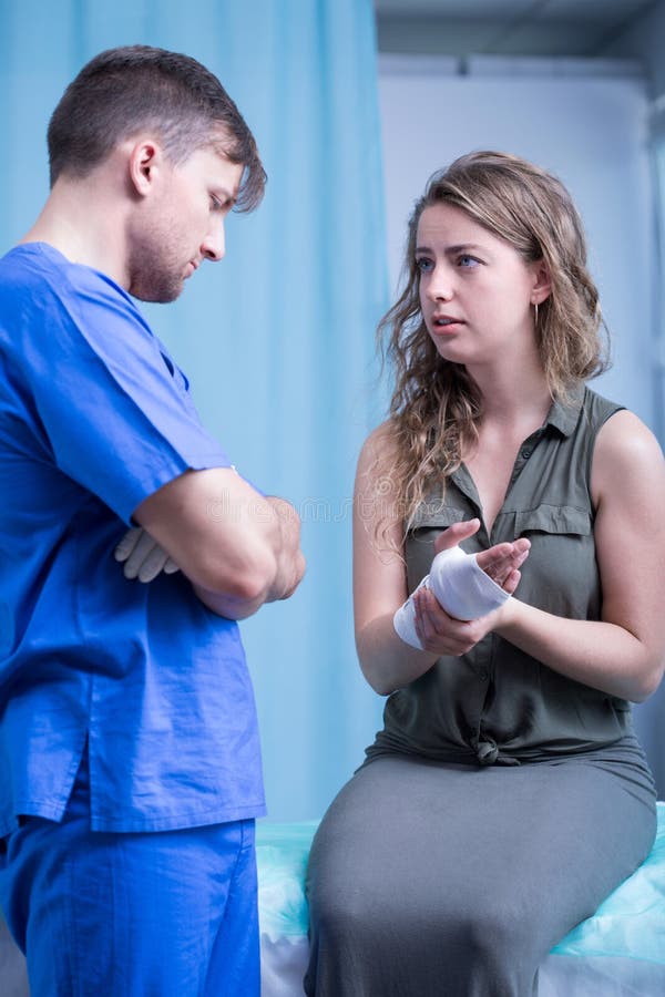 Woman talking with emergency worker. In treatment room stock photography Woman talking with emergency worker. In treatment room stock photography