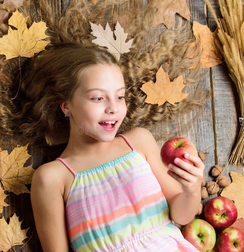 Wow. Small girl likes the taste of apple fruits. Cute girl child with ripe autumn crops. Organic and natural food for royalty free stock images