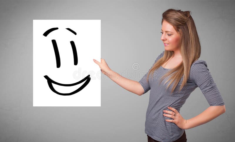 Young woman holding smiley face drawing. Attractive young woman holding smiley face drawing stock illustration