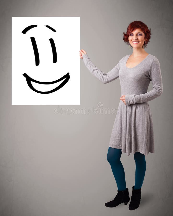 Young woman holding smiley face drawing. Attractive young woman holding smiley face drawing stock illustration