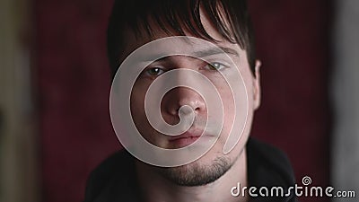 Close up emotional portrait of the young male with a kind face staring at camera with calm expression. Halfturned head. Human Emotions in 60 fps. Close Depicting stock video footage