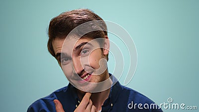 Man flirting with camera on blue background. Portrait of bearded man biting lips. Handsome man flirting with camera on blue background. Close up smiling guy stock video