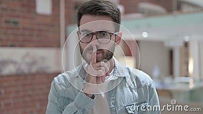 Portrait of Sneaky Young Male Designer Putting Finger on Lips. The Portrait of Sneaky Young Male Designer Putting Finger on Lips stock footage