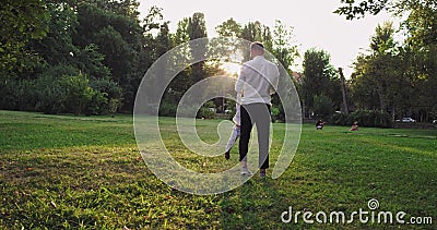 Smiling and happy dad playing lovely with his small son in the middle of the park at sunset enjoying the moment together stock footage
